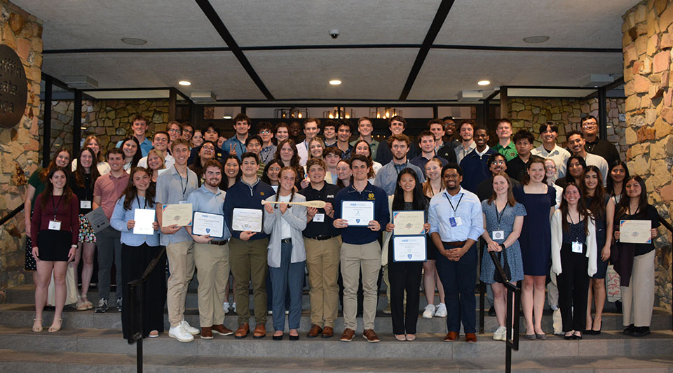A very large group of students pose with award certificates.
