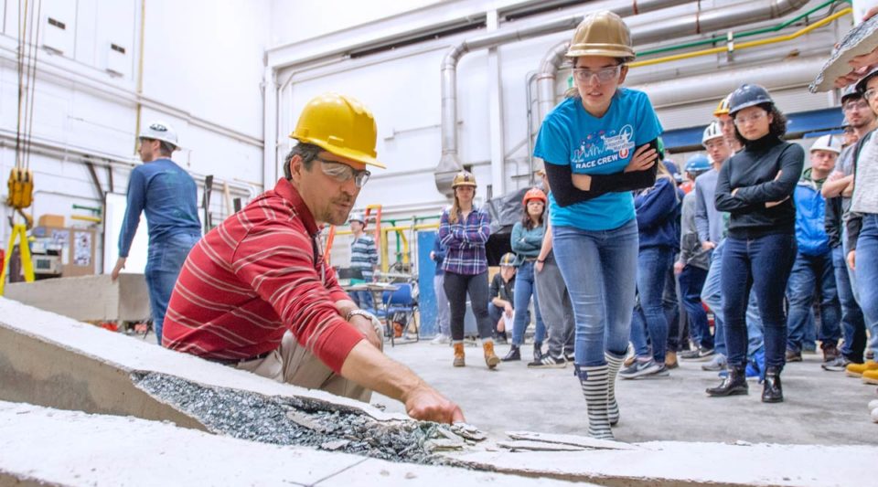 Prof. Kurama pointing to a break in a concrete beam with students in the background.